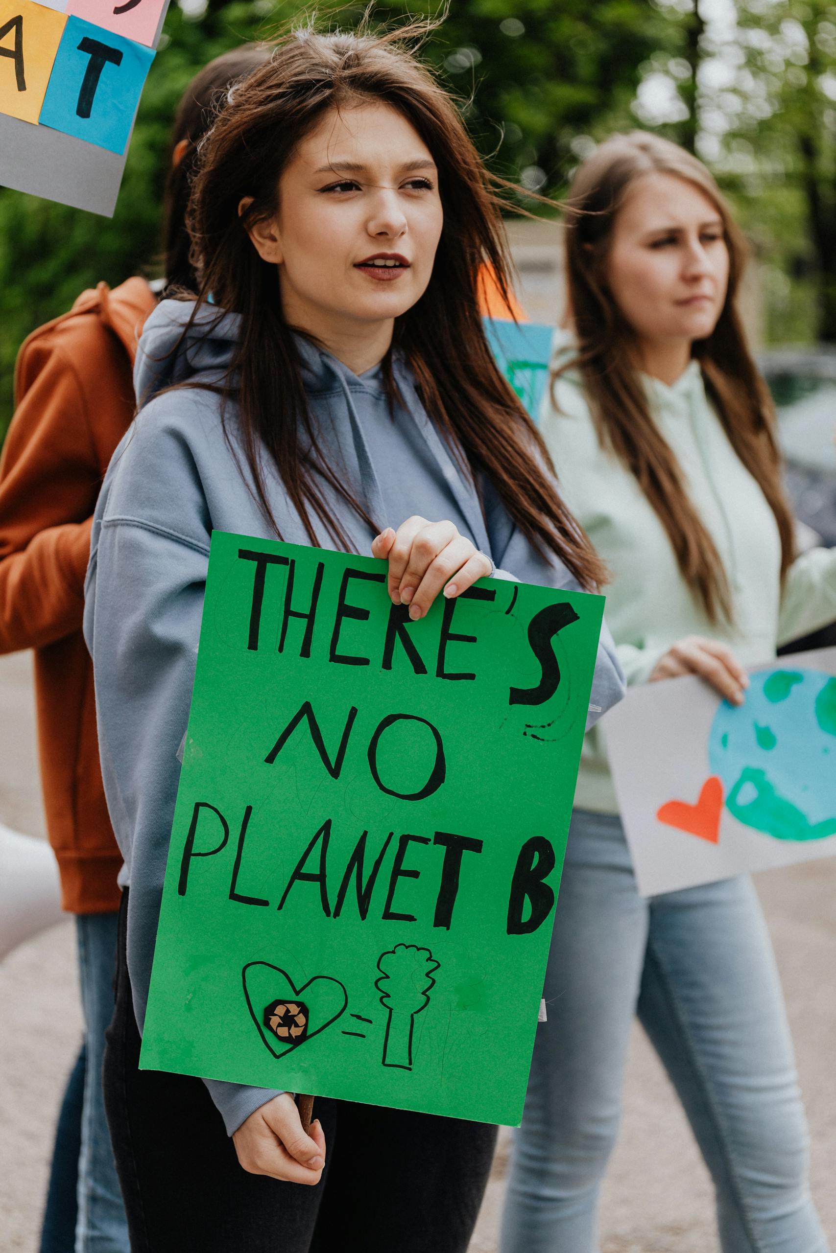 Youth at climate protest rally, holding signs for environmental awareness and change.